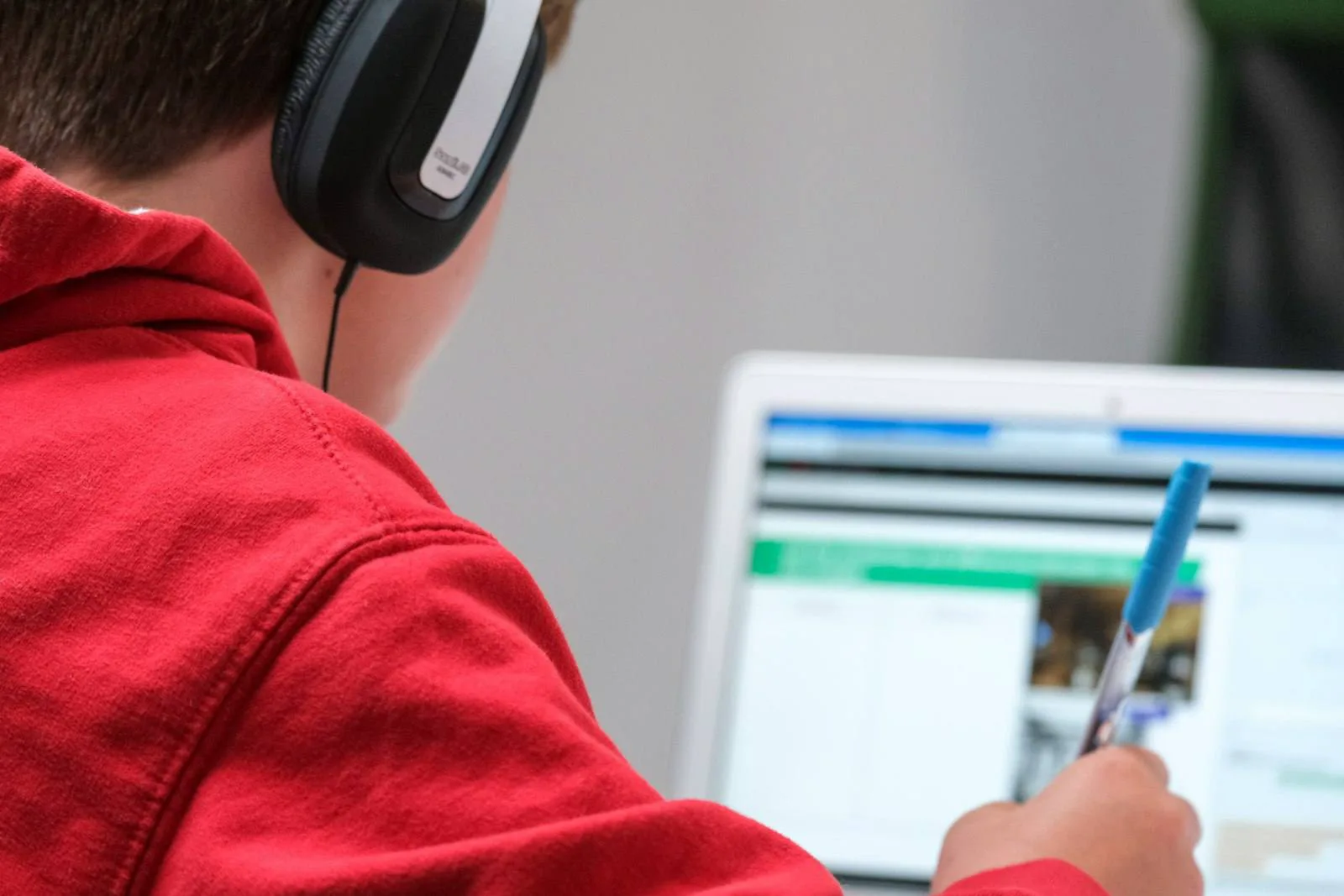 Siswa mengikuti kelas daring memakai headset dan laptop